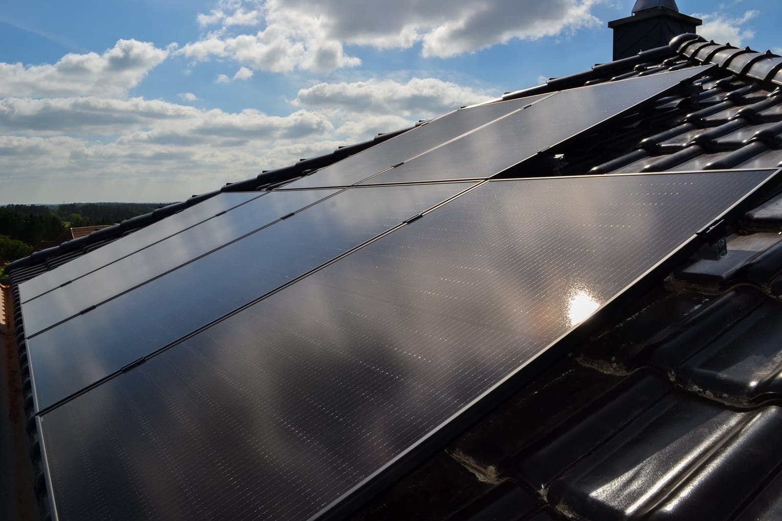 Schwarze Full-Black-Solarmodule auf einem dunklen Ziegeldach im Gegenlicht – Solaranlage von Solar Kammer aus Vastorf bei Lüneburg